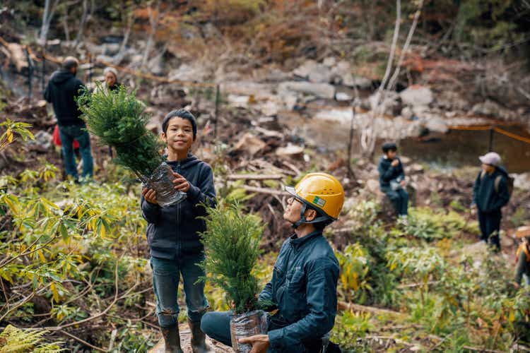 Young boy volunteering to plant seedlings at a reforestation event