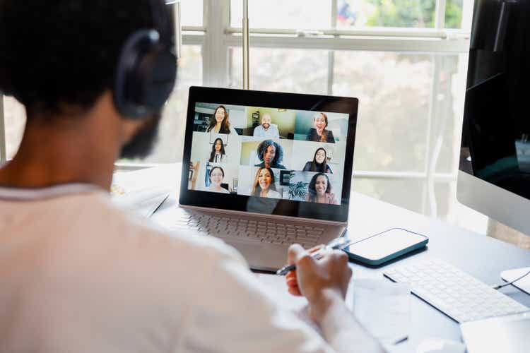 Over-the-shoulder view unrecognizable male college student attending online class