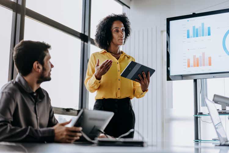 Business woman presenting financial result holding digital tablet