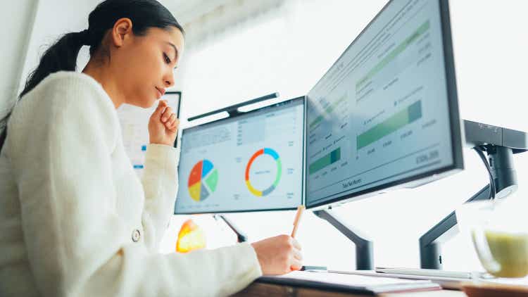 Woman with back pain working at standing desk home office