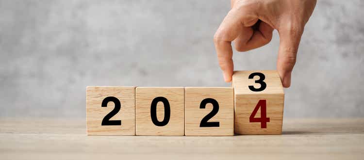 hand flipping block 2023 to 2024 text on table. Resolution, strategy, plan, goal, motivation, reboot, business and New Year holiday concepts