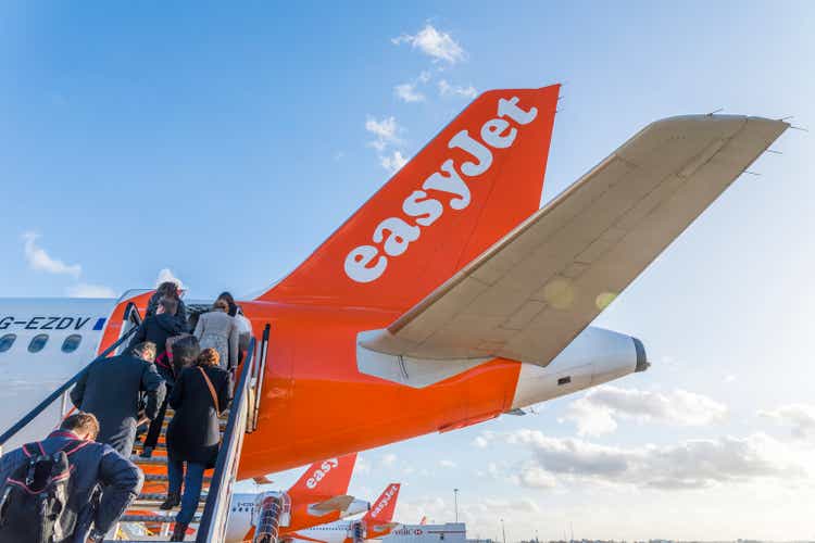 Passengers board an Easyjet airplane at London