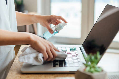 Woman cleaning a MacBook