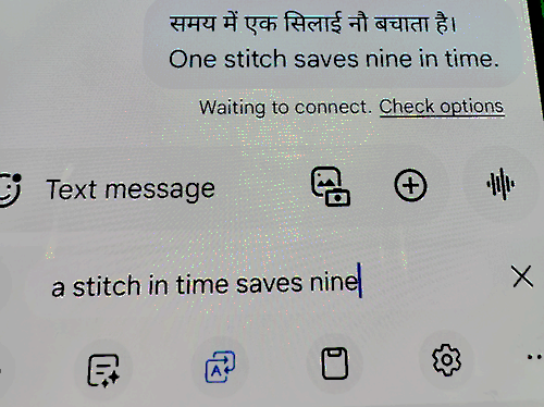 The phrase "a stitch in time saves nine" is translated into Hindi on a phone screen.