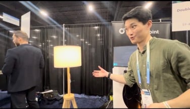 Man in green shirt points at now fully lit lamp