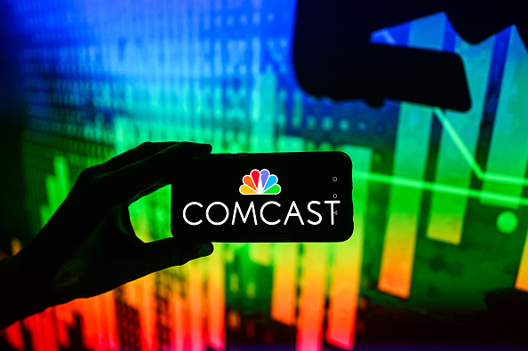 In this photo illustration a Comcast logo is displayed on a...