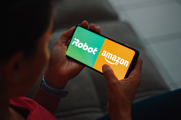 In this photo illustration, the IRobot and Amazon logo is...