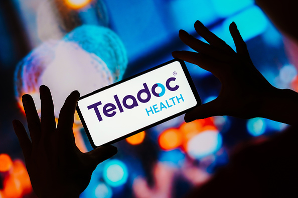 In this photo illustration, the Teladoc Health logo seen...