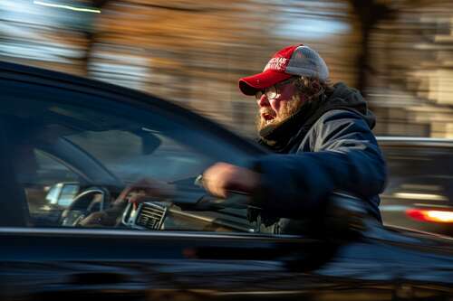 MAGA man hangs on moving car