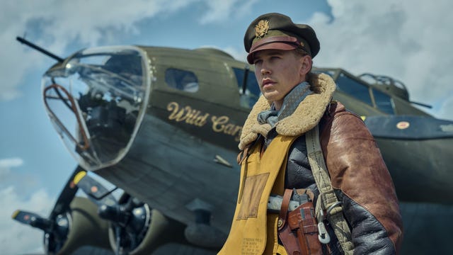 austin butler dressed as world war 2 era pilot standing in front of plane