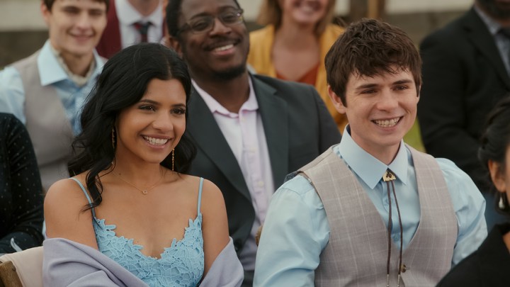 A young woman and man sit all dressed up in a scene from My Life with the Walter Boys on Netflix.