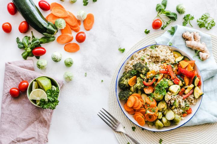 Stock image showing a colorful salad on a plate surrounded by other vegetables and food.