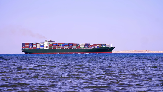 Red sea, a large cargo ship sails on the sea.