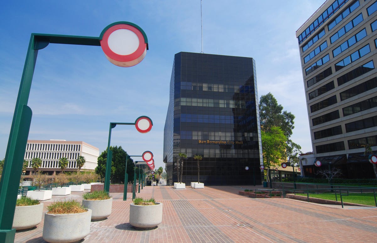 A scene from downtown San Bernardino, California, including San Bernardino City Hall, a walkway and art deco lampposts.