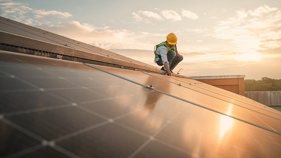 Service engineer checking solar cell on the roof for maintenance if there is a damaged part. Engineer worker install solar panel. Clean energy concept.