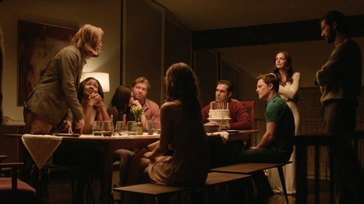 People sit at a table in The Invitation.