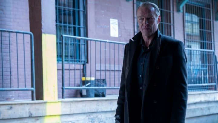 Iain Glen as Bruce Wayne standing on an empty street in Titans