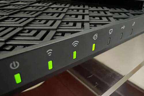 TP Link AX72 router with four green lights.