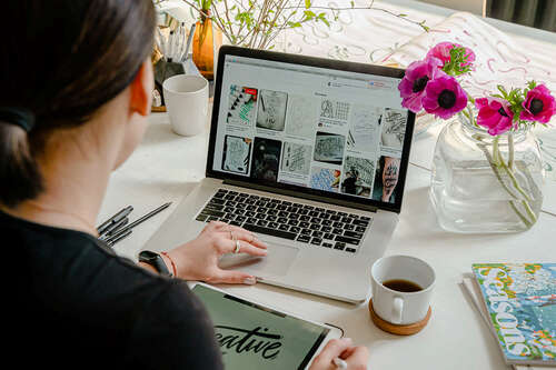 Woman looking at collection of images on a laptop.