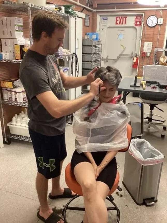 Nathan Jones, emergency medical physician, giving Anca Selariu, U.S. Navy microbiologist, a haircut inside the simulated Mars habitat.