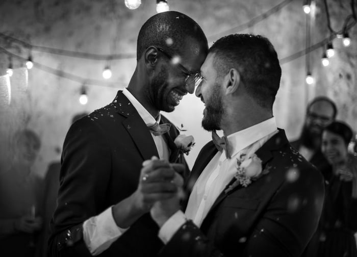 Smiling men dancing at their wedding.