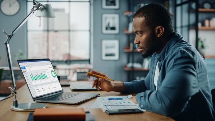 Person looking at charts on a laptop.