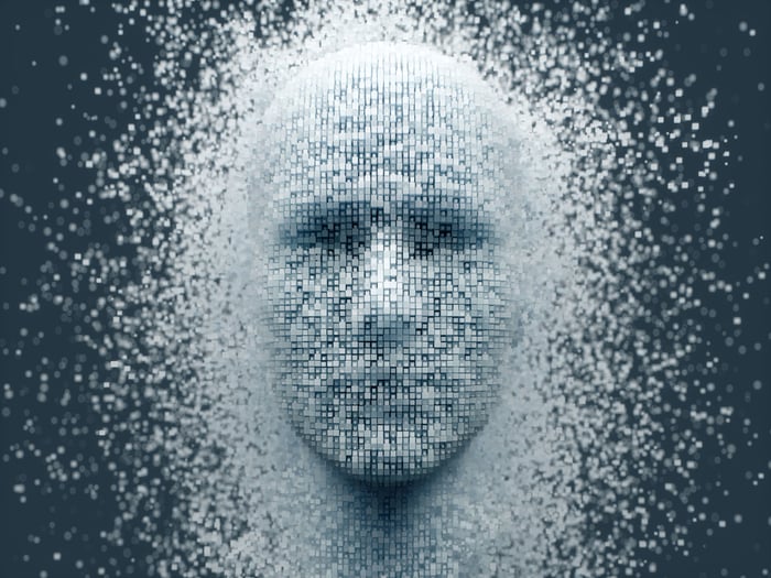 The outline of a human face emerging from a sea of pixels. 