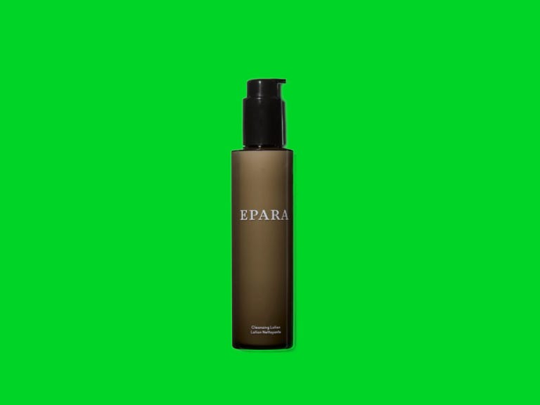 A bottle of black cleansing lotion on a green background