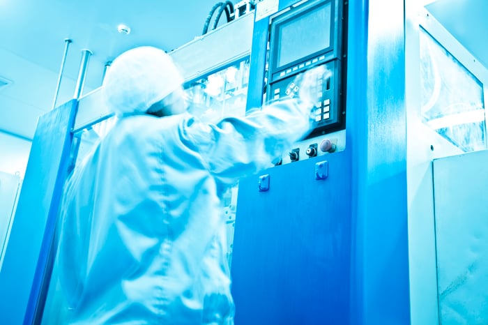 A technician operating inside of a pharmaceutical factory.