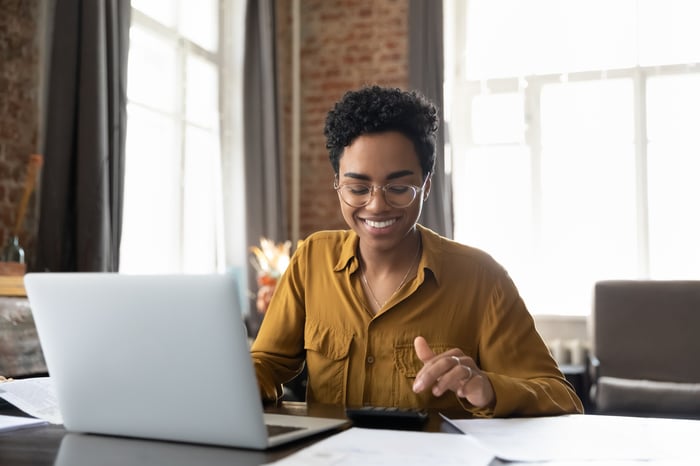 A smiling investor with a computer.