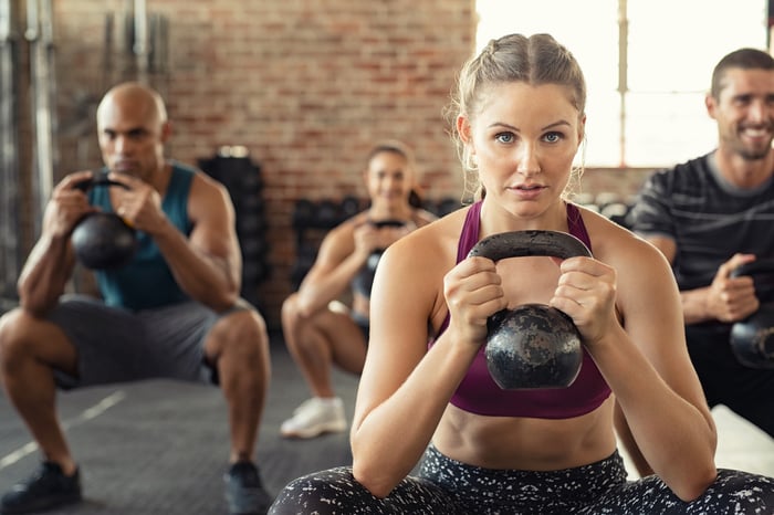 Folks engaging in a group fitness class in a gym.