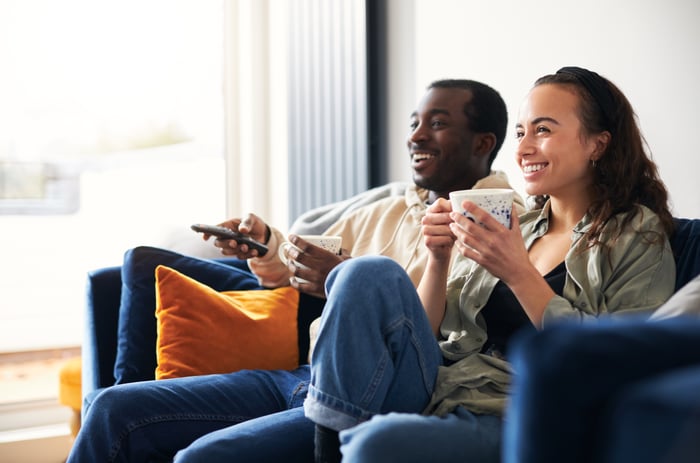 A couple sitting on a couch watching TV