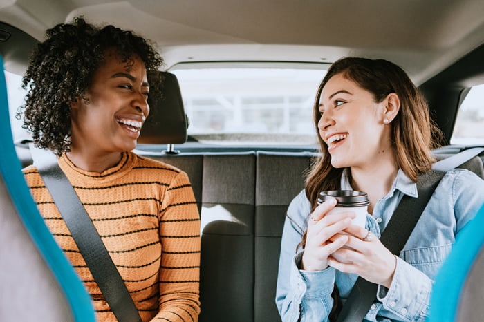 Two ridesharing passengers in the back of a vehicle.