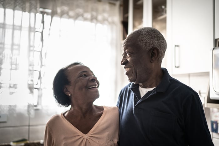 Smiling couple standing in kitchen.