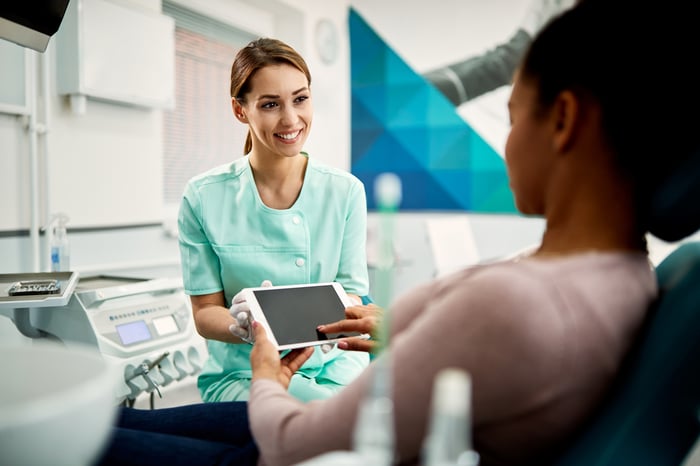 A patient digitally signs a document at a doctor's office.