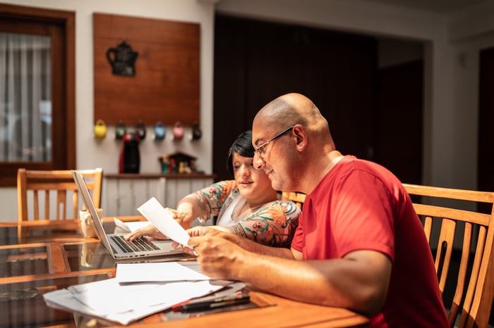 Two adults looking at financial paperwork. 