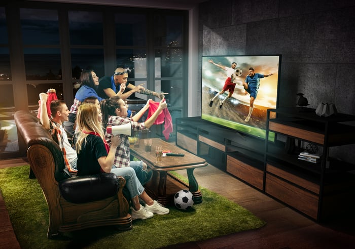 Friends watching a soccer game on TV.