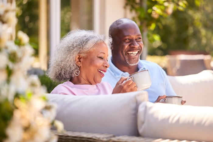 Two people enjoying coffee on patio.