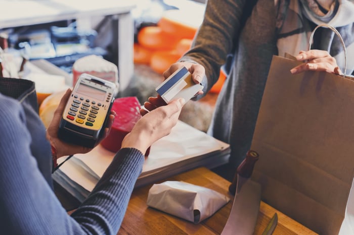 A person makes a credit card payment at a store.