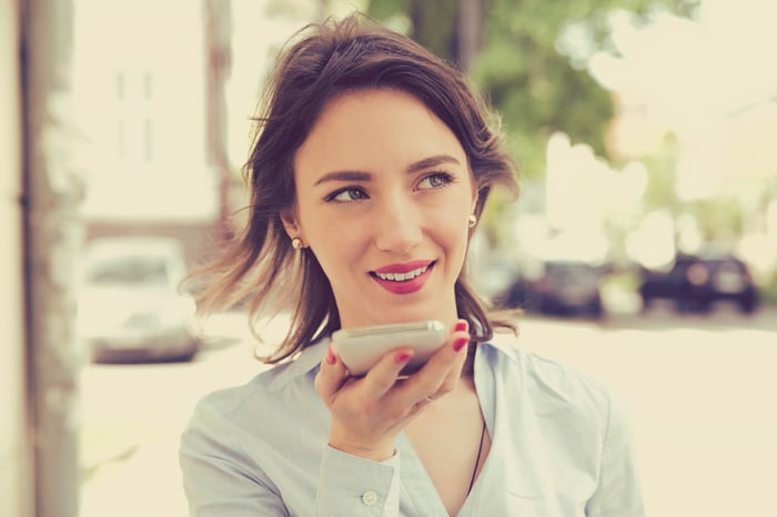 A person uses a voice assistant app on a smartphone.