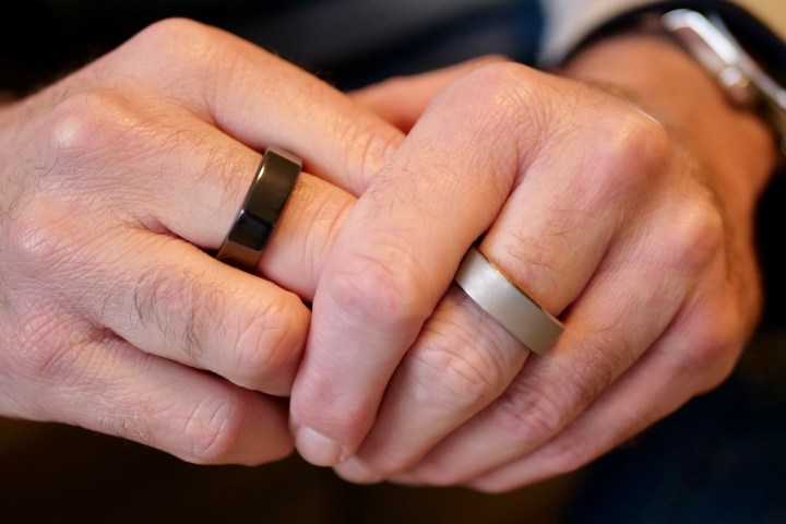 A person wearing the Oura Ring and the RingConn Smart Ring.