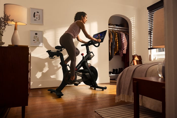 A person rides a Peloton bike at home.