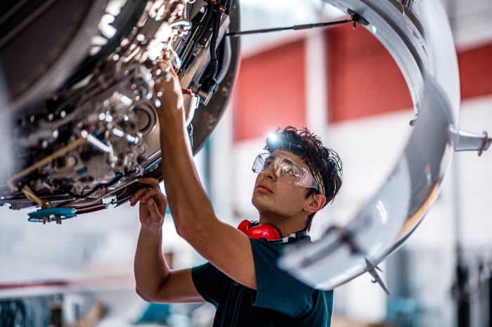 A person wearing personal protective equipment working in aerospace.