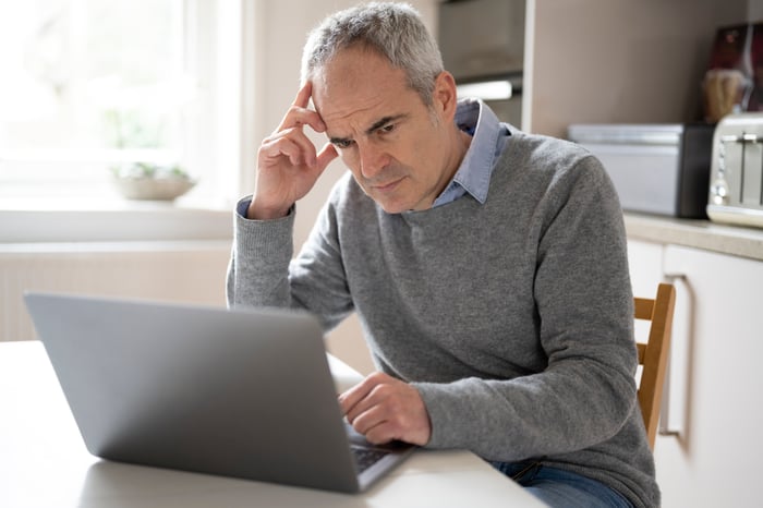 A person with a serious expression at a laptop.