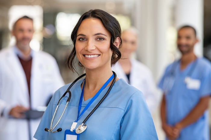 Smiling medical professionals in a hallway.