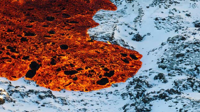 Lava flows across snow-covered ground in southwestern Iceland.