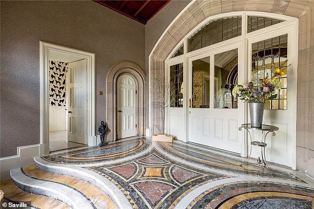 The entrance has a majestic feel with a large door with an arched doorway and multi-coloured, decorative flooring