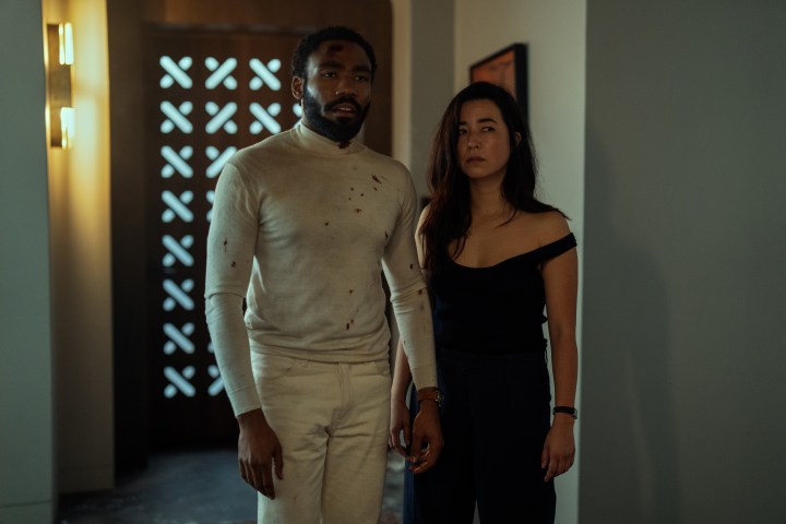 A bloodied Donald Glover stands next to a disheveled Maya Erskine in Mr. & Mrs. Smith.