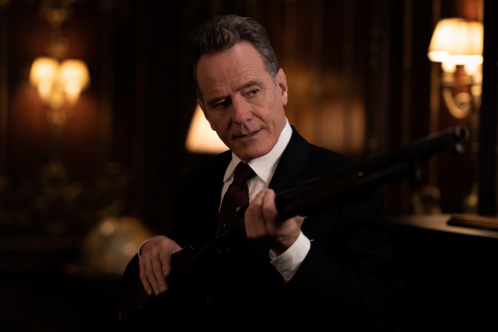 Bryan Cranston holds a shotgun in Argylle.