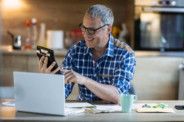 Man smiling while working out finances at home